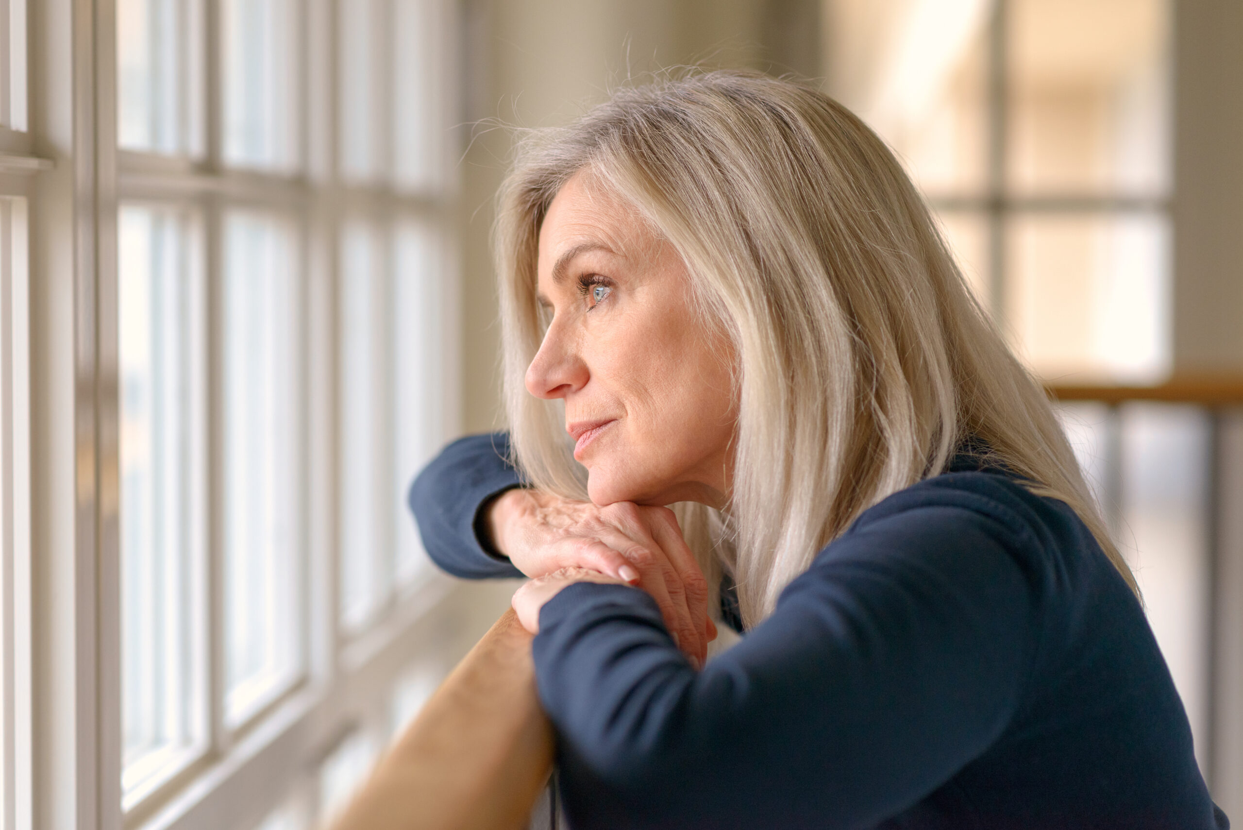 Thoughtful woman looking out a window.