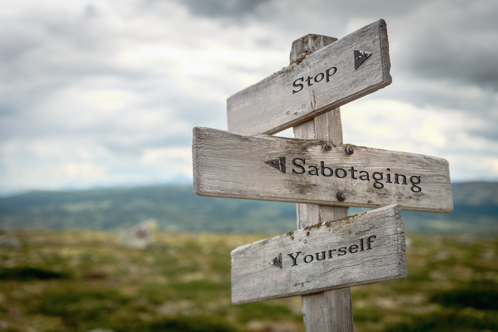 Wooden sign that says "Stop sabotaging yourself."